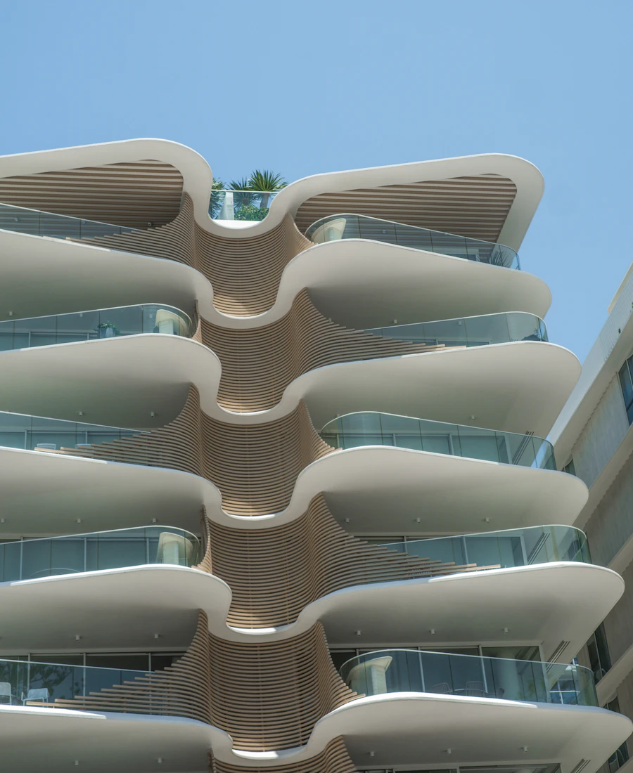 Sculpted curved balconies on a modern residential building against a blue sky